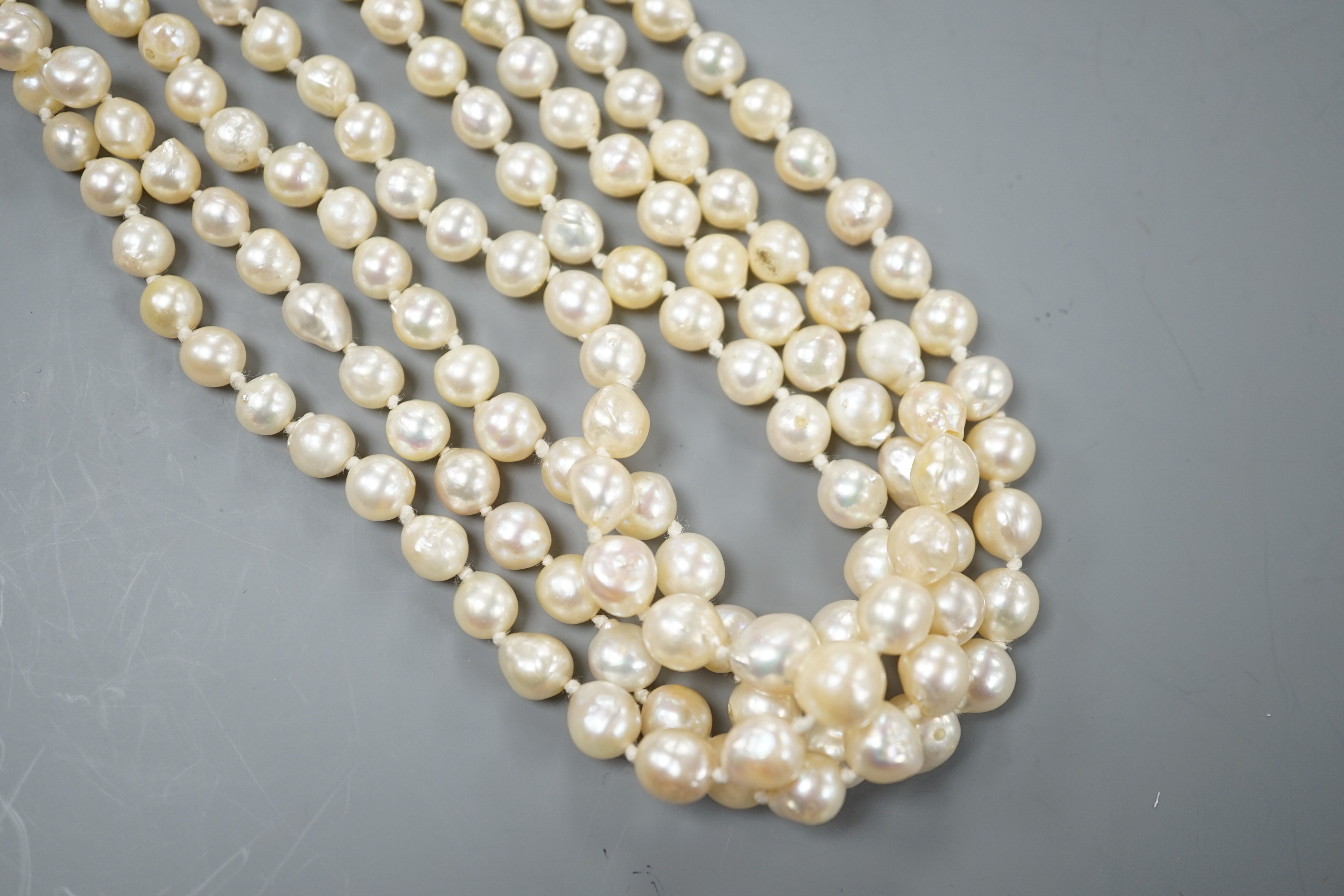 A 1960's triple strand cultured pearl necklace, with garnet and seed pearl set 9ct gold clasp, 48cm.